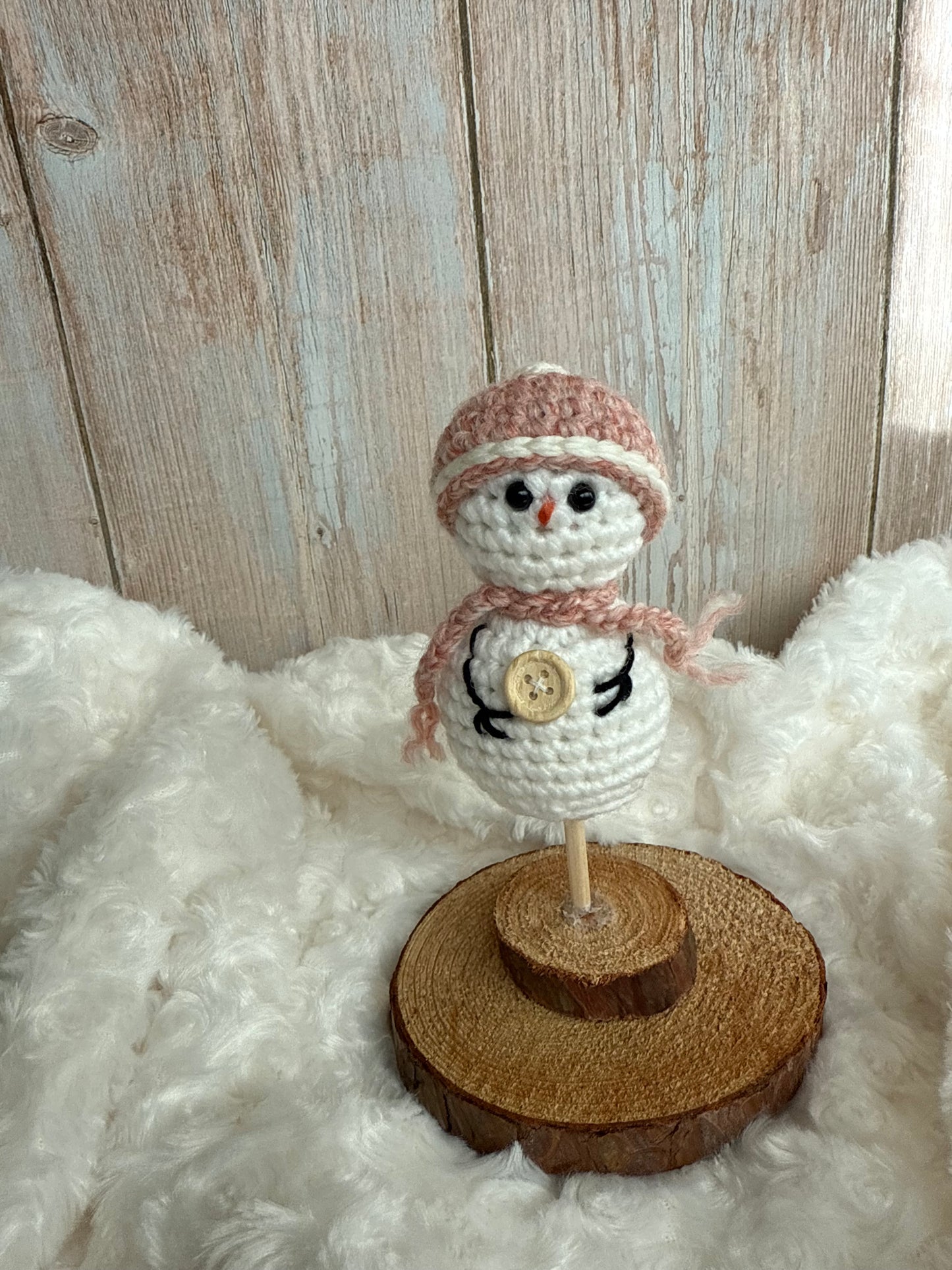 Handmade Crochet Snowman with Hat and Scarf – Winter Table Decor, Crochet Snowman on Wooden Base – Cozy Rustic Christmas Decoration, Mini Crochet Snowman – Cute Handmade Holiday Figurine, Crochet Snowman with Button Details – Perfect Winter Gift