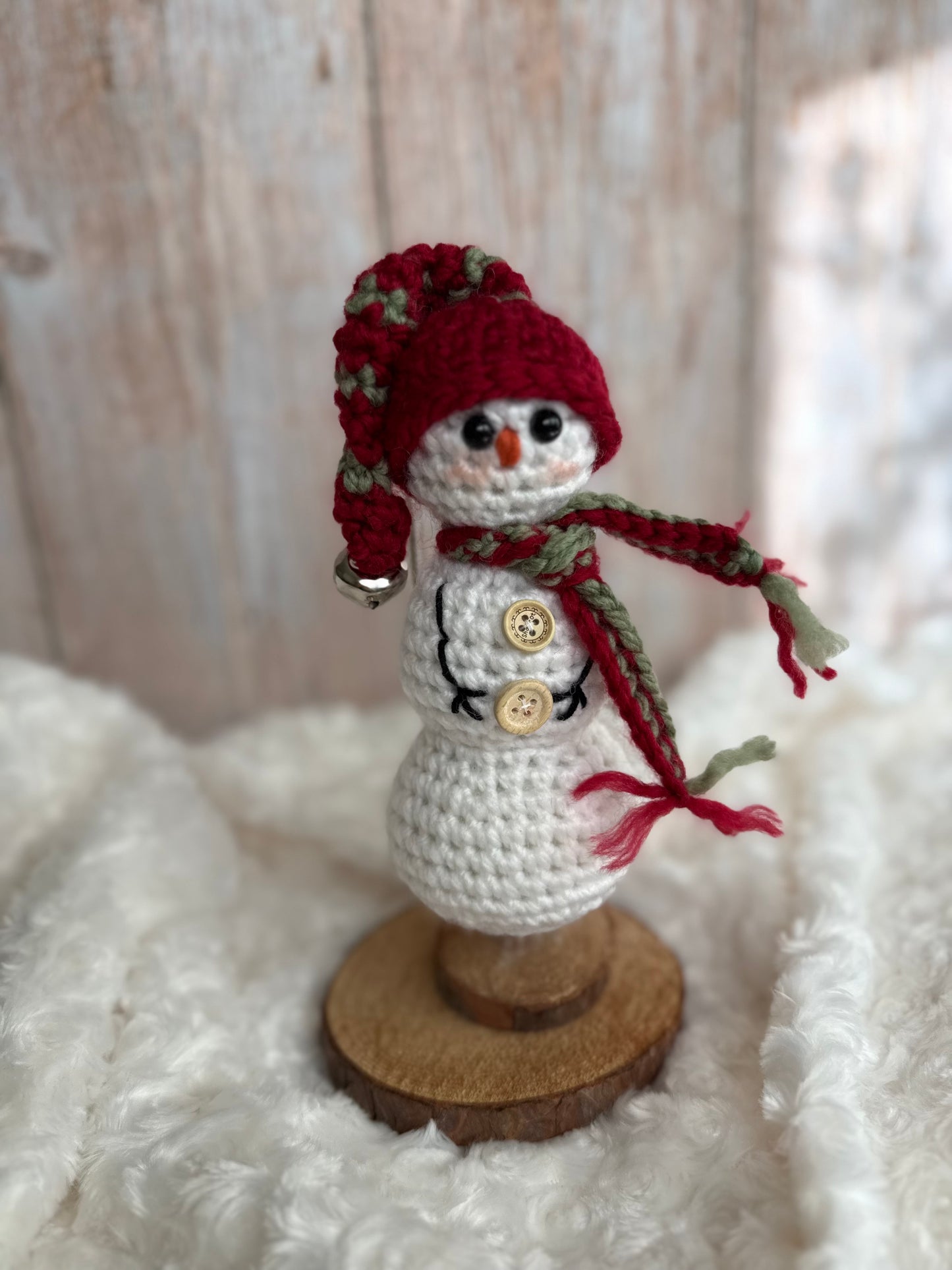 Handmade Crochet Snowman with Hat and Scarf – Winter Table Decor, Crochet Snowman on Wooden Base – Cozy Rustic Christmas Decoration, Mini Crochet Snowman – Cute Handmade Holiday Figurine, Crochet Snowman with Button Details – Perfect Winter Gift