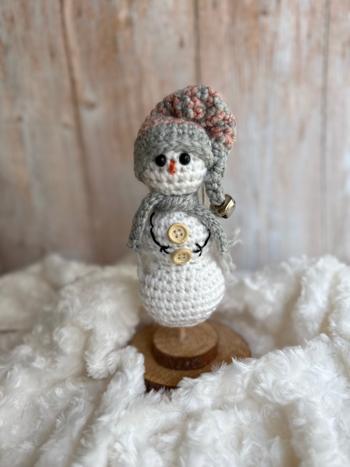 Handmade Crochet Snowman with Hat and Scarf – Winter Table Decor, Crochet Snowman on Wooden Base – Cozy Rustic Christmas Decoration, Mini Crochet Snowman – Cute Handmade Holiday Figurine, Crochet Snowman with Button Details – Perfect Winter Gift