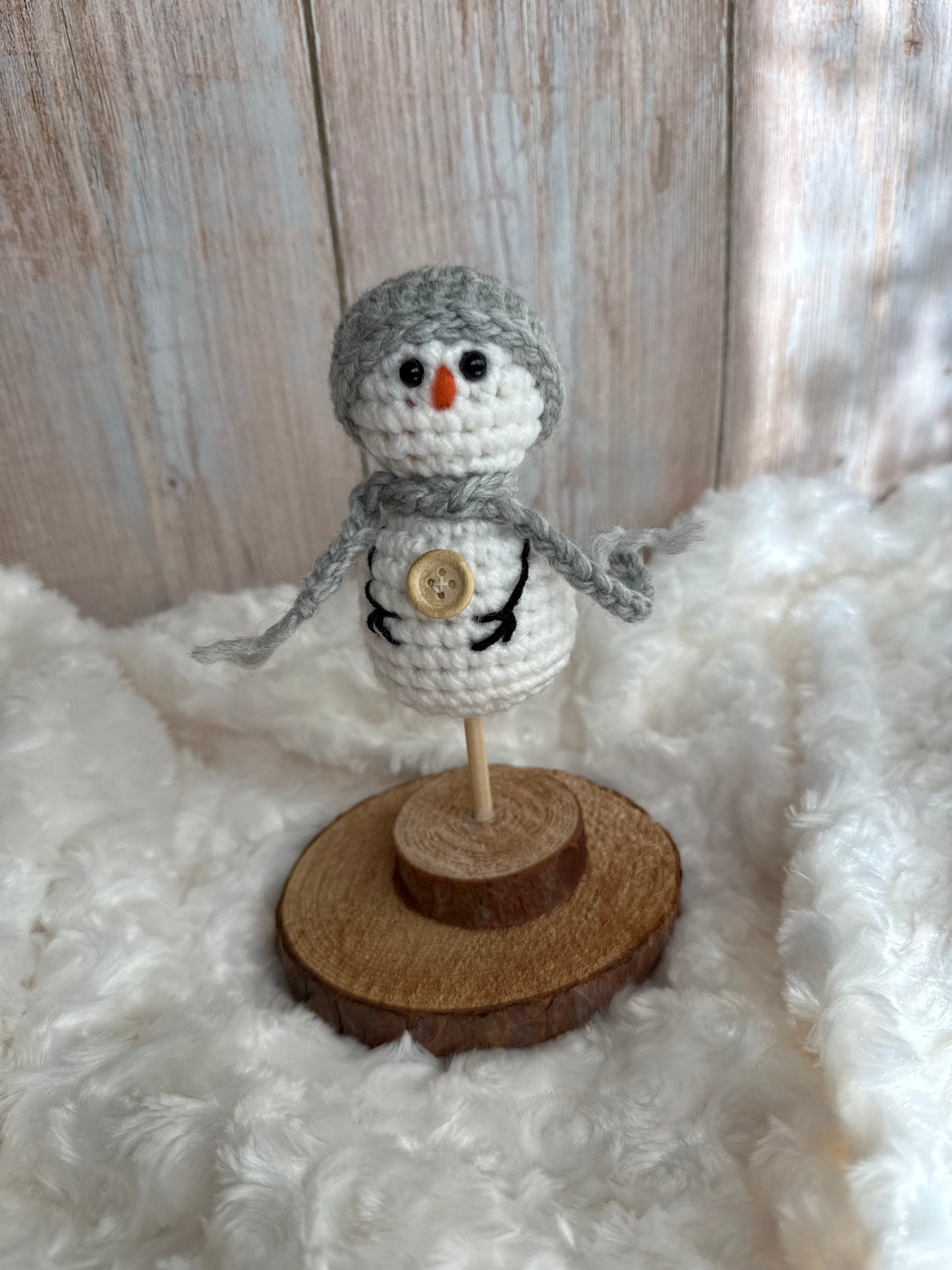 Handmade Crochet Snowman with Hat and Scarf – Winter Table Decor, Crochet Snowman on Wooden Base – Cozy Rustic Christmas Decoration, Mini Crochet Snowman – Cute Handmade Holiday Figurine, Crochet Snowman with Button Details – Perfect Winter Gift