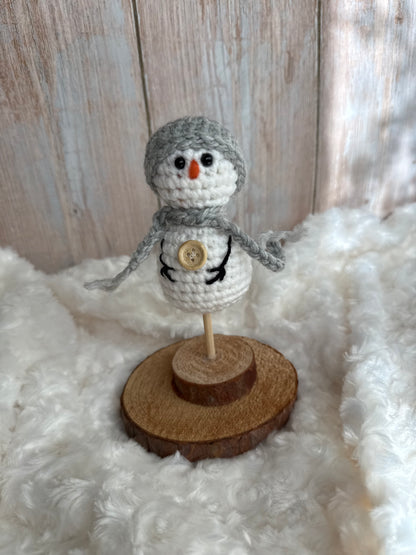 Handmade Crochet Snowman with Hat and Scarf – Winter Table Decor, Crochet Snowman on Wooden Base – Cozy Rustic Christmas Decoration, Mini Crochet Snowman – Cute Handmade Holiday Figurine, Crochet Snowman with Button Details – Perfect Winter Gift
