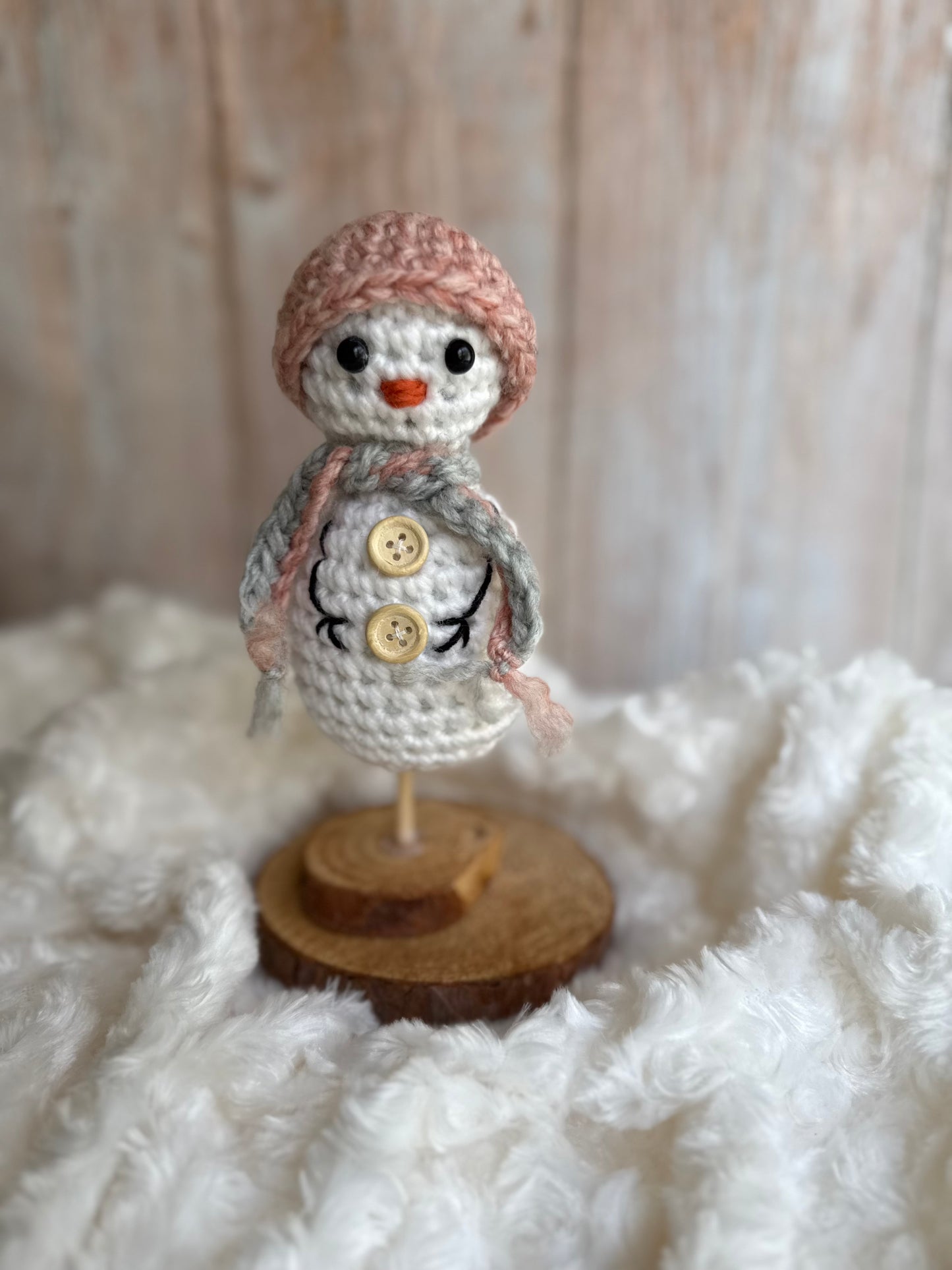 Handmade Crochet Snowman with Hat and Scarf – Winter Table Decor, Crochet Snowman on Wooden Base – Cozy Rustic Christmas Decoration, Mini Crochet Snowman – Cute Handmade Holiday Figurine, Crochet Snowman with Button Details – Perfect Winter Gift