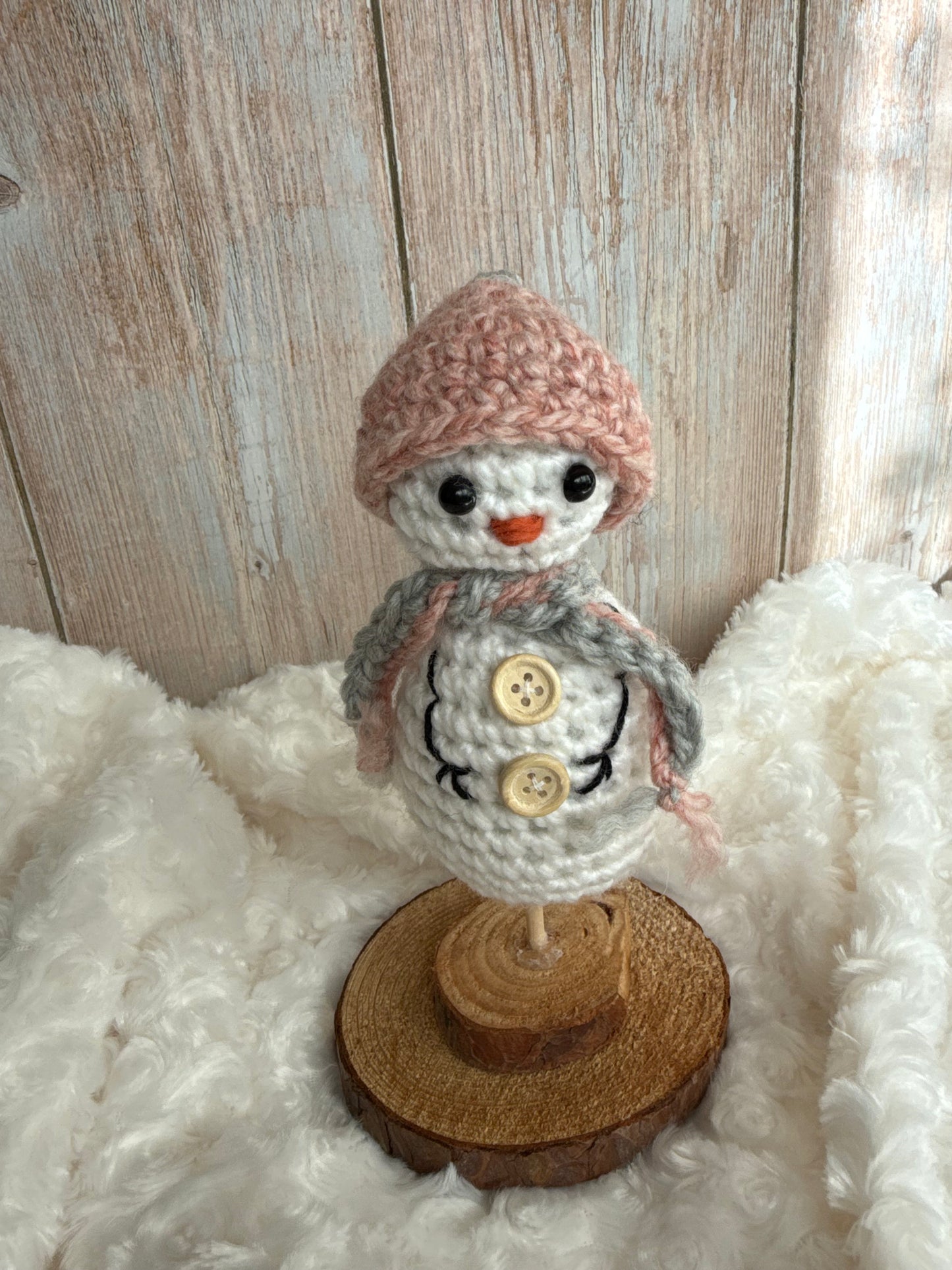 Handmade Crochet Snowman with Hat and Scarf – Winter Table Decor, Crochet Snowman on Wooden Base – Cozy Rustic Christmas Decoration, Mini Crochet Snowman – Cute Handmade Holiday Figurine, Crochet Snowman with Button Details – Perfect Winter Gift