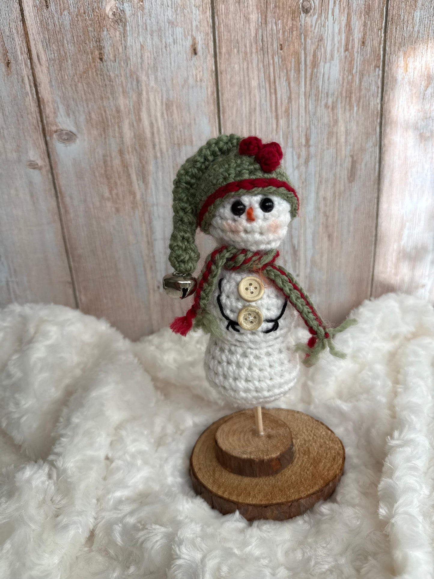 Handmade Crochet Snowman with Hat and Scarf – Winter Table Decor, Crochet Snowman on Wooden Base – Cozy Rustic Christmas Decoration, Mini Crochet Snowman – Cute Handmade Holiday Figurine, Crochet Snowman with Button Details – Perfect Winter Gift