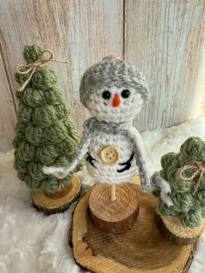 Handmade Crochet Snowman with Hat and Scarf – Winter Table Decor, Crochet Snowman on Wooden Base – Cozy Rustic Christmas Decoration, Mini Crochet Snowman – Cute Handmade Holiday Figurine, Crochet Snowman with Button Details – Perfect Winter Gift