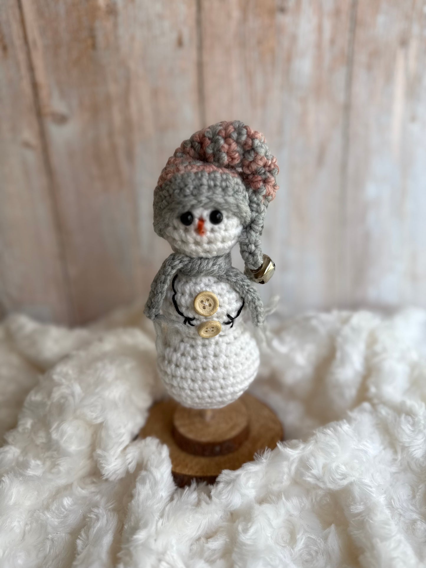 Handmade Crochet Snowman with Hat and Scarf – Winter Table Decor, Crochet Snowman on Wooden Base – Cozy Rustic Christmas Decoration, Mini Crochet Snowman – Cute Handmade Holiday Figurine, Crochet Snowman with Button Details – Perfect Winter Gift