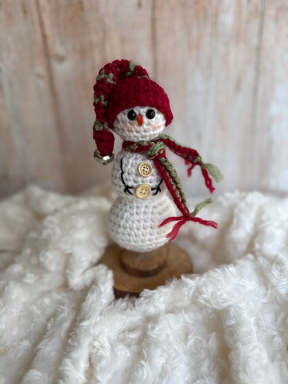 Handmade Crochet Snowman with Hat and Scarf – Winter Table Decor, Crochet Snowman on Wooden Base – Cozy Rustic Christmas Decoration, Mini Crochet Snowman – Cute Handmade Holiday Figurine, Crochet Snowman with Button Details – Perfect Winter Gift