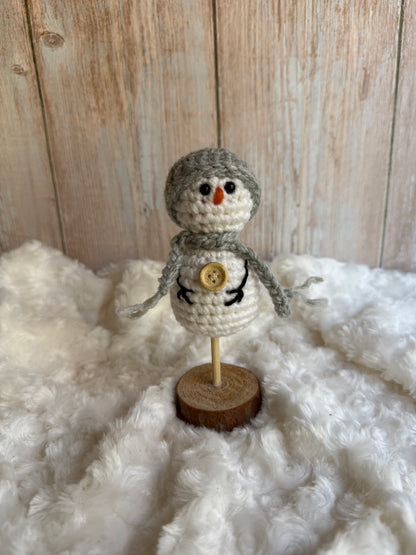 Handmade Crochet Snowman with Hat and Scarf – Winter Table Decor, Crochet Snowman on Wooden Base – Cozy Rustic Christmas Decoration, Mini Crochet Snowman – Cute Handmade Holiday Figurine, Crochet Snowman with Button Details – Perfect Winter Gift