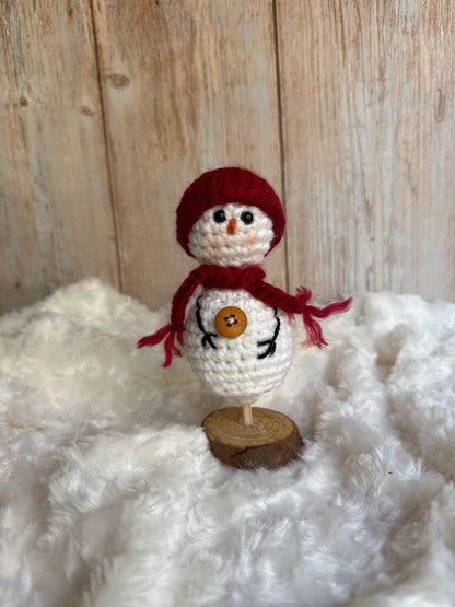 Handmade Crochet Snowman with Hat and Scarf – Winter Table Decor, Crochet Snowman on Wooden Base – Cozy Rustic Christmas Decoration, Mini Crochet Snowman – Cute Handmade Holiday Figurine, Crochet Snowman with Button Details – Perfect Winter Gift
