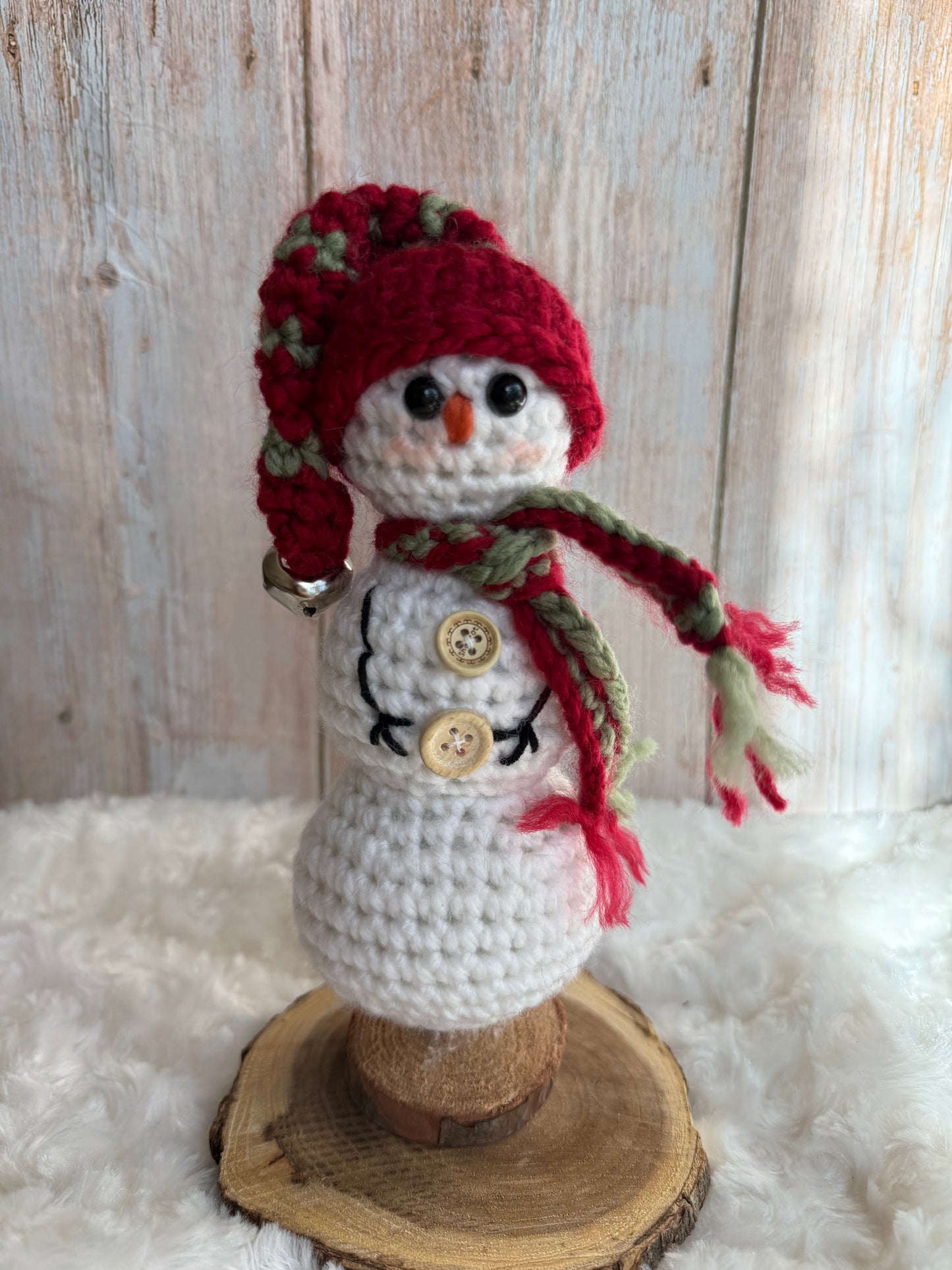 Handmade Crochet Snowman with Hat and Scarf – Winter Table Decor, Crochet Snowman on Wooden Base – Cozy Rustic Christmas Decoration, Mini Crochet Snowman – Cute Handmade Holiday Figurine, Crochet Snowman with Button Details – Perfect Winter Gift