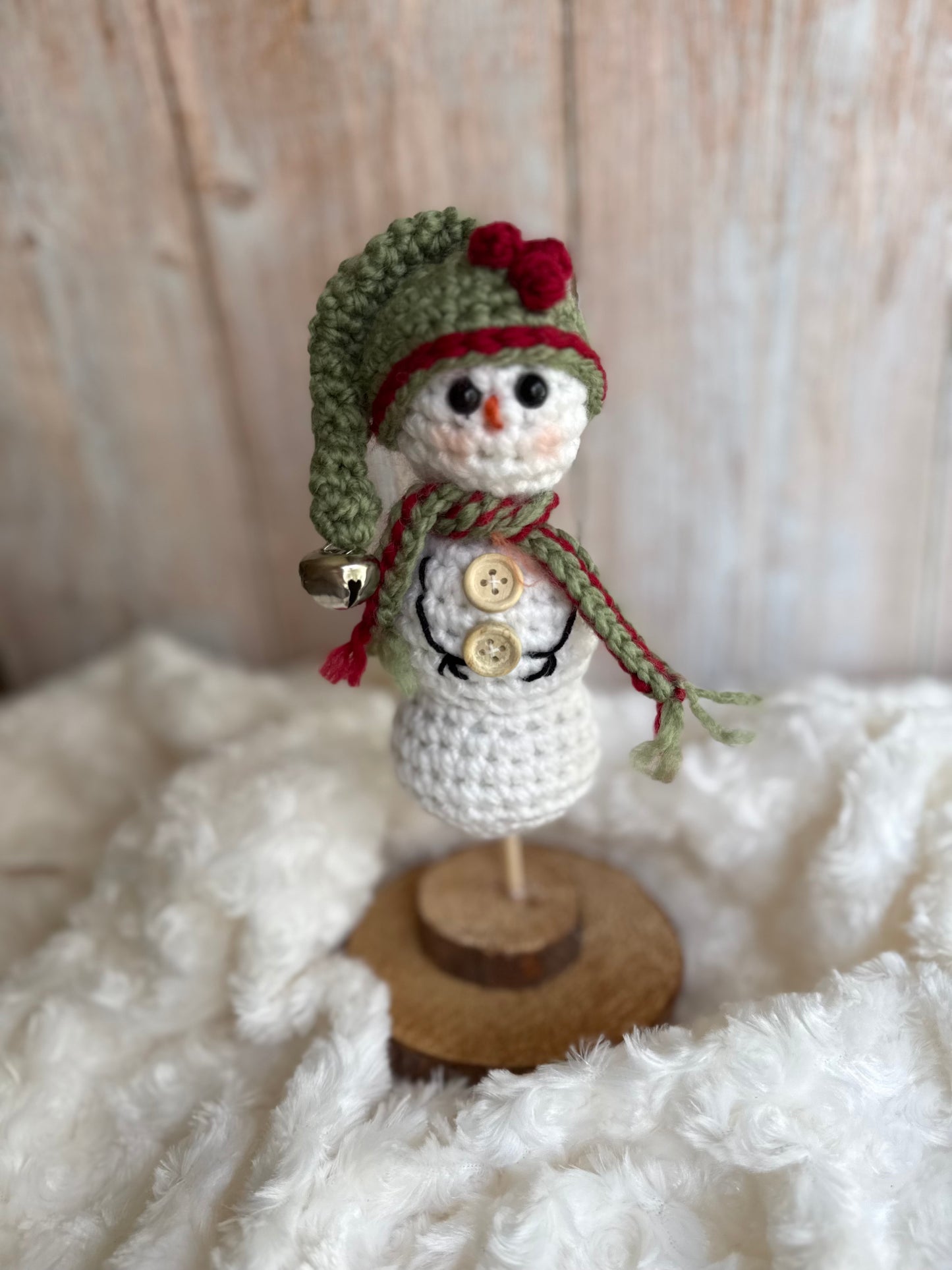 Handmade Crochet Snowman with Hat and Scarf – Winter Table Decor, Crochet Snowman on Wooden Base – Cozy Rustic Christmas Decoration, Mini Crochet Snowman – Cute Handmade Holiday Figurine, Crochet Snowman with Button Details – Perfect Winter Gift