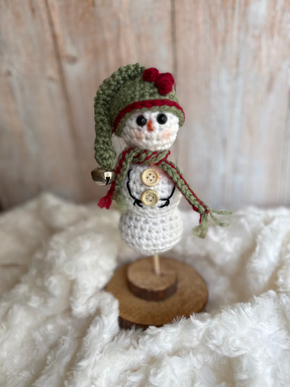 Handmade Crochet Snowman with Hat and Scarf – Winter Table Decor, Crochet Snowman on Wooden Base – Cozy Rustic Christmas Decoration, Mini Crochet Snowman – Cute Handmade Holiday Figurine, Crochet Snowman with Button Details – Perfect Winter Gift