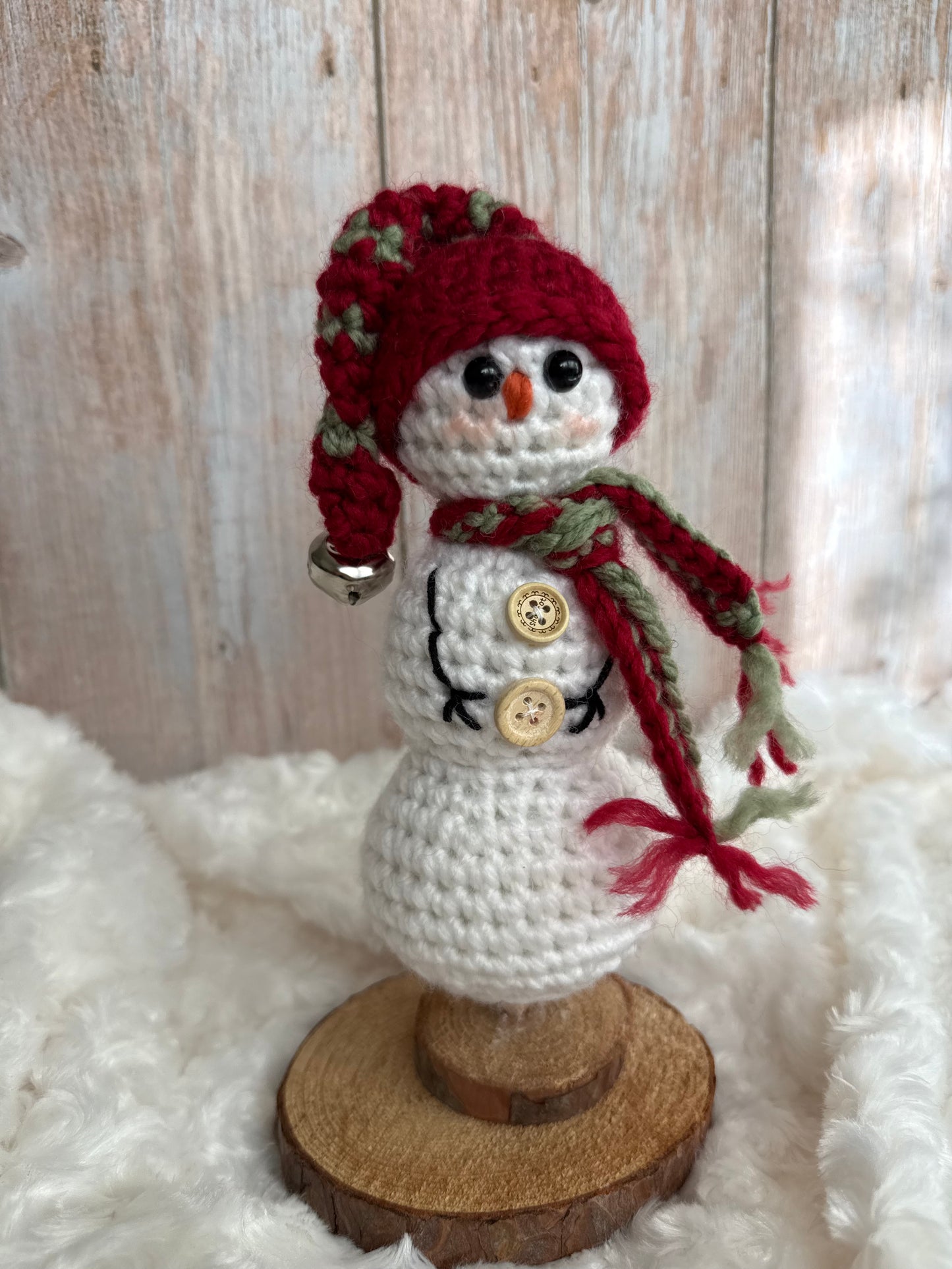 Handmade Crochet Snowman with Hat and Scarf – Winter Table Decor, Crochet Snowman on Wooden Base – Cozy Rustic Christmas Decoration, Mini Crochet Snowman – Cute Handmade Holiday Figurine, Crochet Snowman with Button Details – Perfect Winter Gift