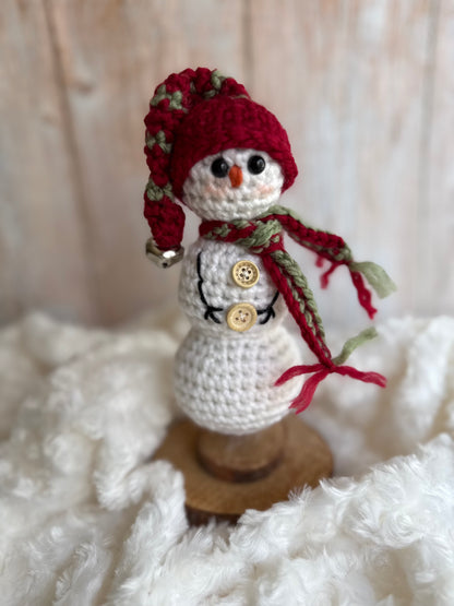 Handmade Crochet Snowman with Hat and Scarf – Winter Table Decor, Crochet Snowman on Wooden Base – Cozy Rustic Christmas Decoration, Mini Crochet Snowman – Cute Handmade Holiday Figurine, Crochet Snowman with Button Details – Perfect Winter Gift