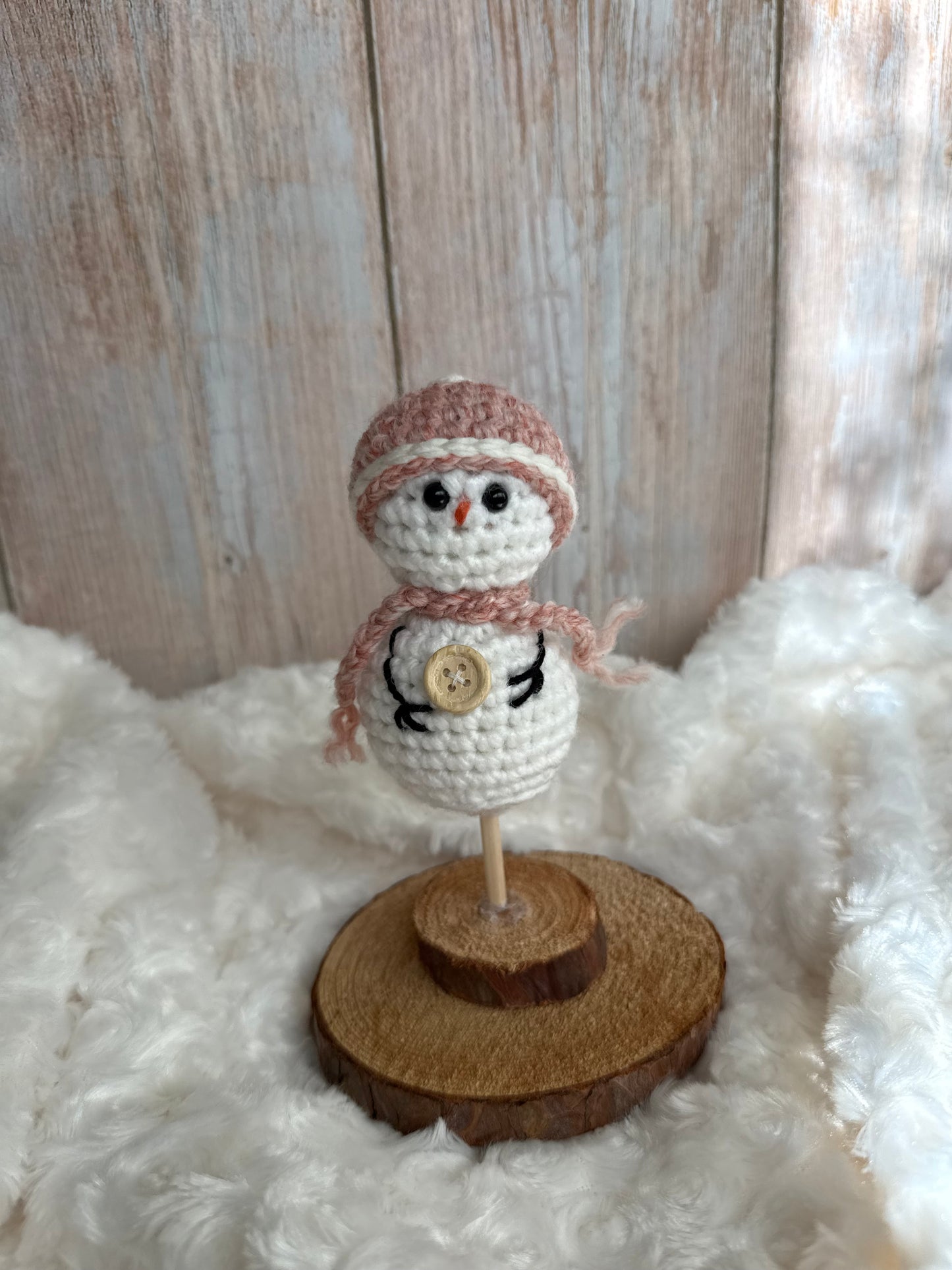 Handmade Crochet Snowman with Hat and Scarf – Winter Table Decor, Crochet Snowman on Wooden Base – Cozy Rustic Christmas Decoration, Mini Crochet Snowman – Cute Handmade Holiday Figurine, Crochet Snowman with Button Details – Perfect Winter Gift