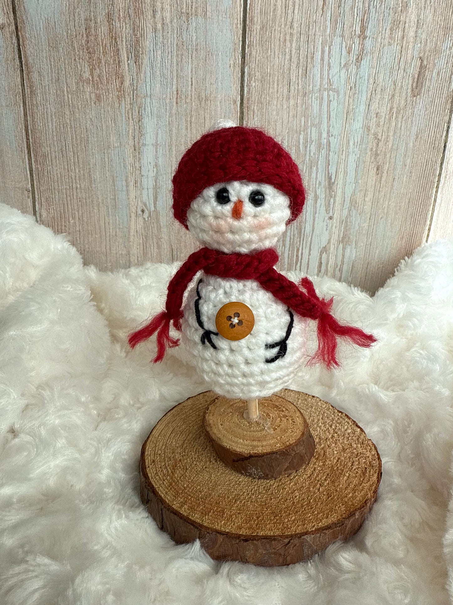 Handmade Crochet Snowman with Hat and Scarf – Winter Table Decor, Crochet Snowman on Wooden Base – Cozy Rustic Christmas Decoration, Mini Crochet Snowman – Cute Handmade Holiday Figurine, Crochet Snowman with Button Details – Perfect Winter Gift
